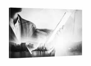 BW double exposure of city and business man using digital tablet
