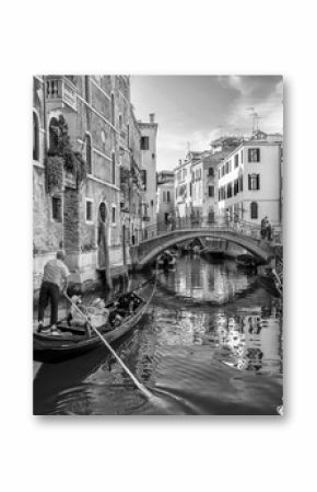 Beautiful black and white view of a typical venetian canal, Fondamenta dei Preti, Venice, Italy, with a couple on a gondola, taking pictures and making video