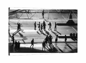 Basketball players silhouettes on Brooklyn pier court at sunset, New York City, USA.