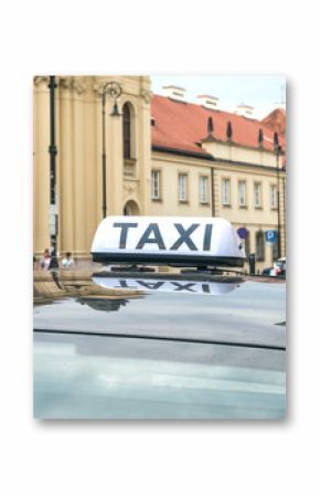 Sign and symbol of a taxi on the roof of a black car in the historic part of the old city