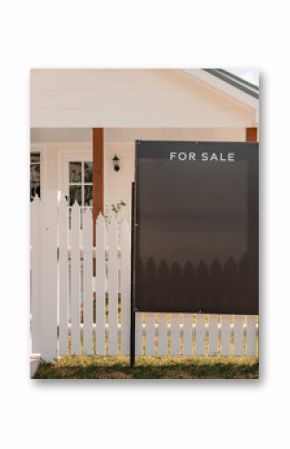 For sale sign along picket fence surrounded small white cottage