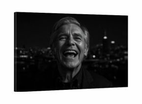 Elderly man laughing joyfully during nighttime cityscape background black and white photography portrait candid emotion happiness urban mood street light shadows