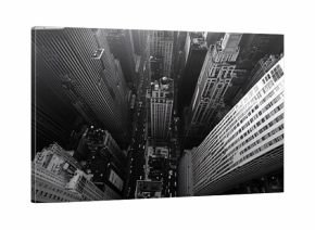 The illustration shows a high-angle, black and white view of densely packed city buildings and a street with traffic.