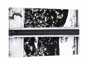 Aerial view of the frozen Neris River speckled with ice floes, bisected by a bridge with a lone car crossing, a stark contrast of black water and white banks, Vilnius, Vilnius, Lithuania.