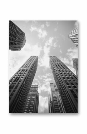 A black and white photo of a city skyline with tall buildings. The sky is cloudy and the buildings are very tall