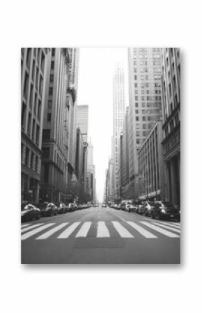 Black and white photo of a city street with tall buildings and crosswalk.