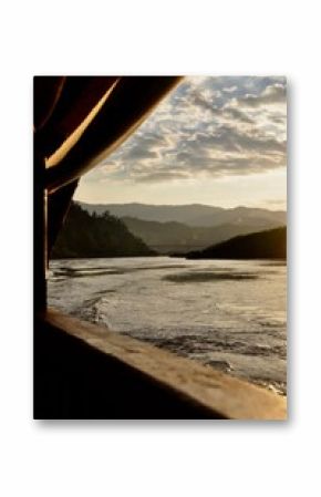  Standing at the threshold of the boat's doorway, Beyond the gentle sway of the boat, the vista opens up to reveal a breathtaking panorama of mountains and rivers.