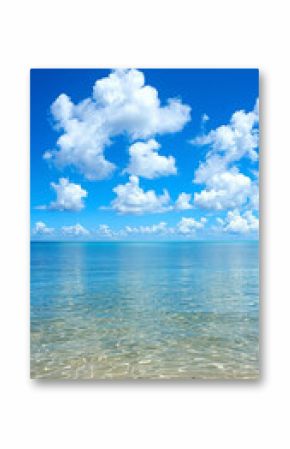 A beautiful blue ocean with a few clouds in the sky