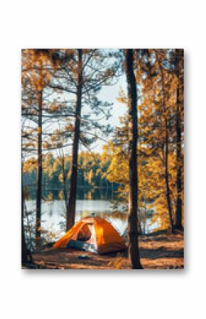 Orange tent by lake surrounded by autumn forest trees.