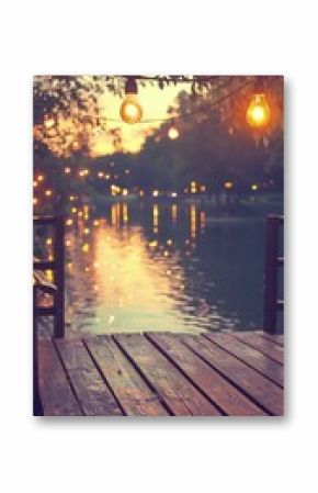 Warm Sunset Over Calm Lake with Illuminated Dock