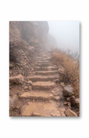 Stone Steps Leading Upward Through Foggy Mountain Cliffside