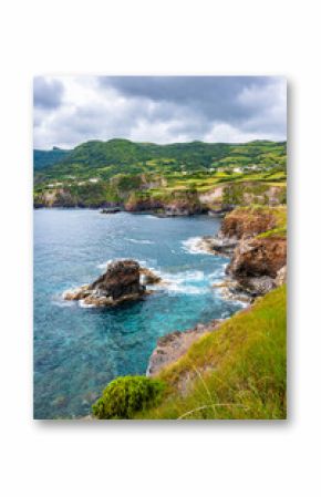 Beautiful bay with rocks on ocean coast with green cliffs at Ponta Delgada, Flores island, Azores, Portugal