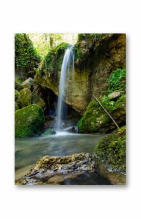 A waterfall is flowing into a small pool of water