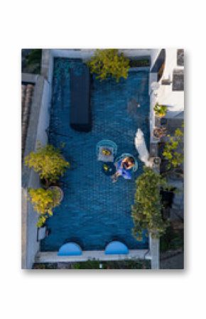 Aerial view of a cozy rooftop terrace where a woman relaxes with a white dog and lemonade. Surrounded by plants and blue tiles, the space evokes calm urban living and pet companionship