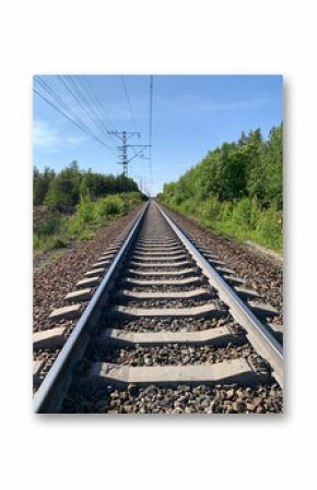A serene railway track winding through a lush green landscape under a cloudy sky. Transportation theme, industrial design and street scenes.