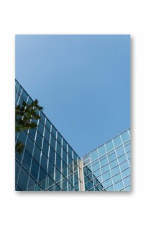 Low angle view of glass office building against blue sky