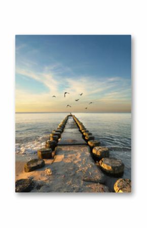 Idyllic Autumn Sunset Over the Baltic Sea with a Weathered Wooden Groyne and Tranquil Coastal Scenery