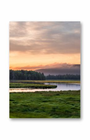 Sunset in Arcadia, Maine USA over a river and mountain landscape.