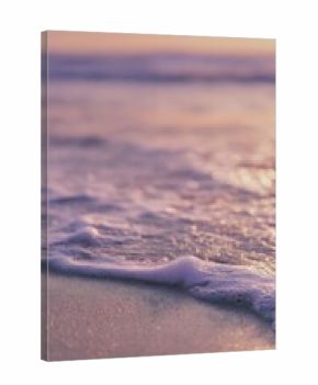 Close-up shoreline with soft waves and sunset horizon