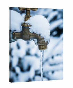 Brass faucet covered in snow, with an icicle forming from its spout, set against a blurred snowy background, conveying winter chill and natural processes