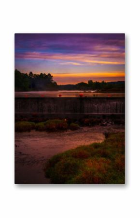 Sunrise lakeshore autumn landscape at Eagleville Pond Dam over the Willimantic River in Coventry, Connecticut
