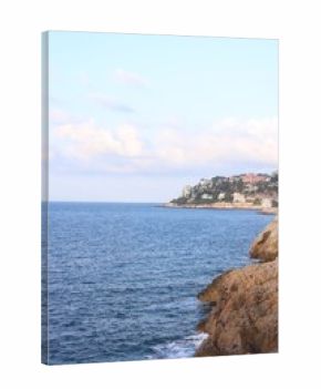 Picturesque view of sea, city and cliff under blue sky