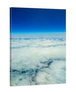 Vast expanse of fluffy clouds under a clear blue sky at high altitude during midday flight