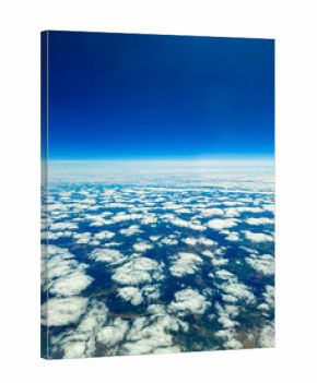 Blue sky blending with white clouds creates a serene view from above the earth, capturing the beauty of nature at midday