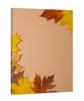 A vertical arrangement of autumn leaves on a brown background 