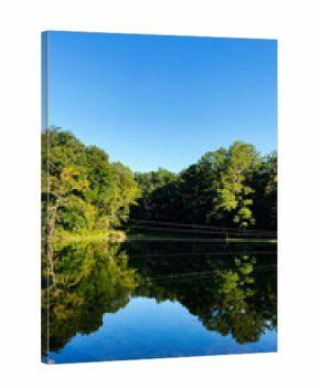 Tranquil lake scene with reflection of trees under a clear blue sky in Southern Illinois USA