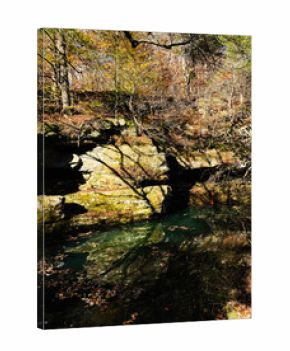 Autumn forest by a rocky creek in Southern Illinois with falling leaves and reflections