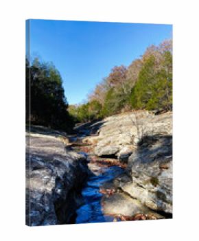 Tranquil rocky stream through Southern Illinois woodland on a clear blue sky day