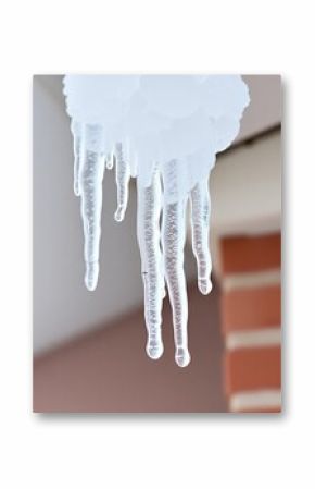  icicles hanging from a roof in front of a building.