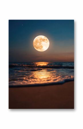 Full moon rising above ocean waves at sunset illuminating beach