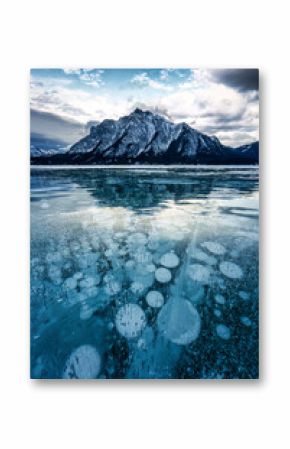 Frozen Abraham Lake with rocky mountains and natural bubbles frost on winter at Kootenay Plains, Canada