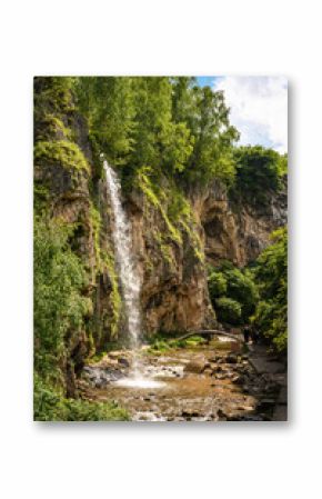 Honey Waterfalls in Kislovodsk, Russia. Water falls into gorge, vertical view of nice canyon and trees in summer. Concept of nature, travel, mountain and forest in Caucasian Mineral Waters.