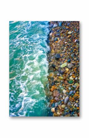 Beautiful summer sea background. Sea turquoise wave washes the pebble shore. Vertical photo.