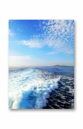 Foam trail in the sea. Boat wake in the sea. Ocean waves and blue sky with white clouds. Seascapes and ocean foam. Relaxation and seabed.