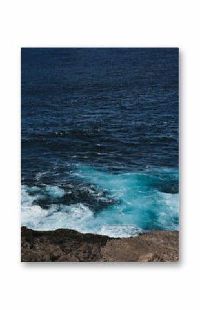 Aerial View of Rough Sea Waves Colliding with Jagged Coastal Rocks