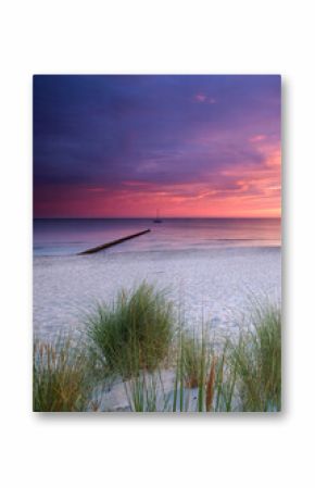 amazing colorful Sunset Over Weathered Wooden Groynes at the beach