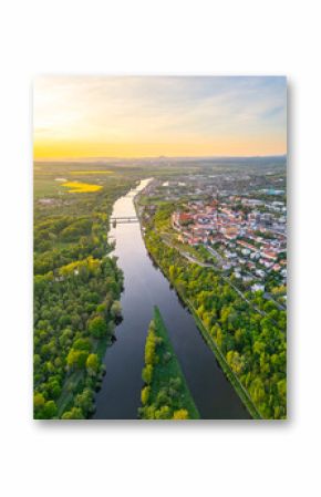 Aerial view reveals the beautiful confluence of the Vltava and Labe rivers close to Melnik, Czechia. Lush green banks and charming towns create a picturesque landscape during sunset.
