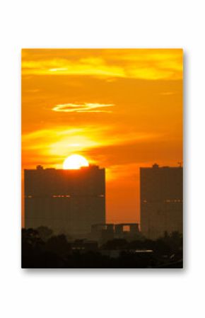 Golden sunset over city skyline creating a vibrant orange sky and dramatic silhouette