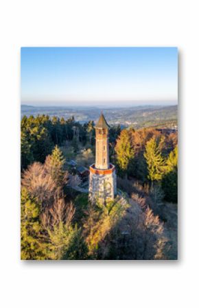 Stepanka Lookout Tower stands tall against a clear blue sky in Korenov, Czechia. Surrounded by lush green trees, this spring morning view offers stunning vistas of the Jizera Mountains.