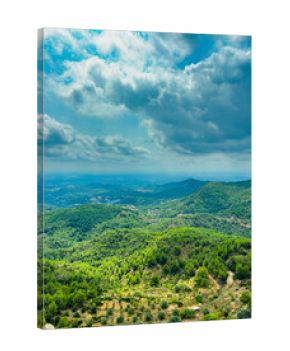 Scenic landscape view from a hilltop with lush green forests and distant mountains under a cloudy sky