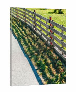 Rural farm fence with metal post and wooden boards in scenic Slovenian countryside landscape.
