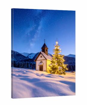 Kapelle mit geschmückten Tannenbaum in Winterlandschaft 