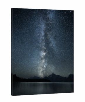 Milky Way stretching over Colter Bay Beach in Grand Teton National Park at night.