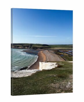Panoramic view of Seven Sisters Cliffs along the East Sussex coast with blue sky and sandy beach