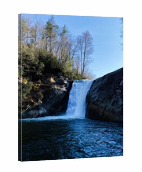 Waterfall Elk River Falls at rocky overlook in North Carolina forest under a clear blue sky