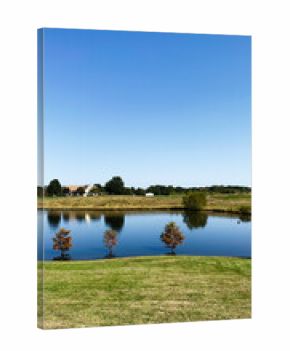 Tranquil lakeside park in Southern Illinois with calm water, blue sky, and trees reflection scene